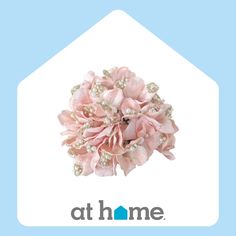 a brooch with pink flowers and pearls on it's center is the at home logo