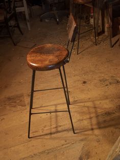 a wooden stool sitting on top of a dirty floor