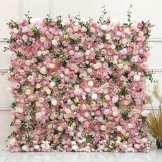 pink and white flowers are arranged on the wall