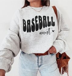 ABOUT OUR Baseball Aunt Sweatshirt: PRODUCTION TIME: 1-3 days (Usually 2 days) SHIPPING TIME: 2-5 days (Usually 3 days) PRODUCT DESCRIPTION: Gildan 18000 Sweatshirt Super soft cotton and excellent quality print makes. 100% Soft cotton (fibre content may vary for different colors) Light fabric (4.2 oz/yd² (142 g/m Runs true to size Our Relaxed Fit Sweatshirt (Gildan 18000) is a unisex style that runs a touch small for men, and about a half a size large for women. It's a relaxed fit and is soft and cozy. * For T-shirt Sizes Please refer to the Listing Image. CARE INSTRUCTION: Machine wash: warm (max 40C or 105F); Non-chlorine: bleach as needed; Tumble dry: low heat; Iron, steam or dry: medium heat; Do not dryclean PRINTING METHOD: DTG printing method is used for these shirts. A process of pr Athletic Heather Long Sleeve T-shirt With Letter Print, Heather Grey Crew Neck Top Fan Apparel, Heather Grey Crew Neck Fan Apparel Top, Heather Grey Cotton Tops With Letter Print, College Heather Grey Tops With Letter Print, Heather Grey Crew Neck Top For Sports Season, Heather Grey Letter Print Top For College, Baseball Season Cotton Sweatshirt With Lettering, Relaxed Fit Tops With Lettering For Sports Events