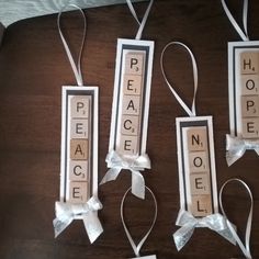 three pieces of paper with words and bows hanging from the sides on a wooden table