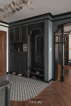 an empty room with wooden floors and black cabinets in the center is a chandelier