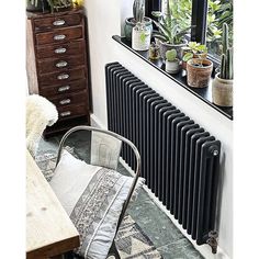 a radiator in the corner of a room with potted plants