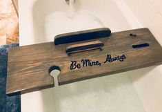 a wooden sign that says be mine, always on the side of a bathtub