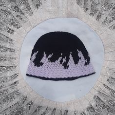 a black and white crocheted hat with trees on it