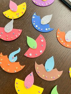 colorful paper cut outs sitting on top of a wooden table