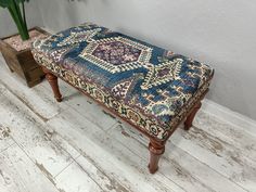 a wooden bench sitting on top of a hard wood floor next to a potted plant