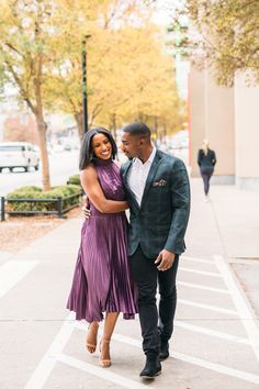 an engaged couple walking down the street together