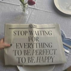 a newspaper sitting on top of a table next to a vase with flowers in it