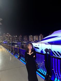 a woman standing next to a railing at night