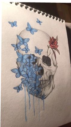 a drawing of a skull with blue butterflies around it and a rose on its head