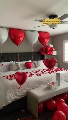 a bedroom decorated for valentine's day with red and white balloons