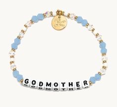 a bracelet with the word godmoter written on it, and beads around it