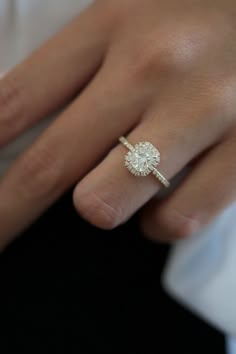 a close up of a person's hand with a diamond ring on their finger