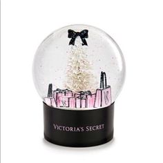 the victoria's secret snow globe has a black bow on it and is in front of a white background