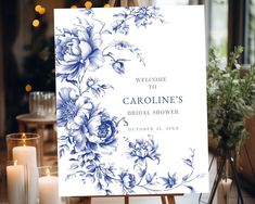 a welcome sign sitting on top of a wooden easel next to candles and flowers