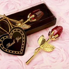 a heart shaped box with a rose and a keychain in the shape of a flower