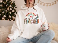 "Preschool Teacher Hoodie, Preschool Hoodie, Pre-K Teacher Teacher Hoodie, Cute Teacher Hoodie, Preschool Teacher Shirt    Hi! Welcome to✨Northstar Sweatshirt &Hoodies✨ ✨As the weather gets colder, you want clothes that keep you and your body warm. Here, Northstar Sweatshirt &Hoodies is ready to keep you warm with its unique designs. These soft and cotton sweatshirts and hoodies can be combined with anything.✨ ✨Product Features✨ 👉Medium-heavy fabric (8.0 oz/yd² (271.25 g/m 👉Loose fit 👉Runs true to size 👉50% cotton, 50% polyester 👉Tear-away label 👉Youth Hoodies do not have drawcord for added safety ✨Care Instructions✨ 👉Wash item inside out in cold water, do not bleach, do not dry clean, do not iron directly on the design. ✨How To Order✨ 👉 First, please review all photos and make sur White Winter Hoodie For School, Winter School Hoodie, Fall School Hoodie With Letter Print, Fall School Hoodie Sweatshirt, School Hoodie Sweatshirt With Drawstring Hood, Hooded Hoodie With Drawstring For School, Cotton Hoodie For School, Winter School Sweatshirt With Letter Print, School Hoodie With Drawstring Hood