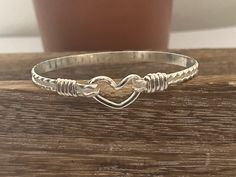 This is a handcrafted bangle/bracelets. It is designed with an oval shape to ensure a proper fit. It is the perfect gift for mothers, sisters, birthdays, daughters, and lovers. This is a simple classy bracelets.  It is  5mm in wide, handcrafted wire-wrapped bangle bracelet, wire wrapped in sterling silver. A dainty, elegant bracelet that can be used as a statement piece. All my materials are14K gold-filled and/or sterling silver and are purchased from reputable jewelers. These bracelets will not tarnish. No plated materials. Wear it every day!   This bracelet can be ordered in 6, 7, 8, or 8.5 and inches. The most common size is 7.5. If this does not match your needs please contact me. When measuring for the bracelet, measure your wrist size.  order your snug wrist size, not your bracelet s Wire Wrapped Bangle Jewelry For Anniversary, Adjustable Wire Wrapped Bracelet For Anniversary, Adjustable Sterling Silver Bangle For Anniversary, Handmade Silver Bracelet For Friendship, Handmade Silver Friendship Bracelet, Sterling Silver Hand Wrapped Bangle, Adjustable Sterling Silver Bangle, Hand Wrapped Sterling Silver Bangle, Adjustable Sterling Silver Bangle Stamped 925