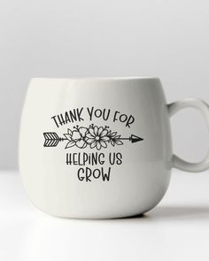 a white coffee cup with the words thank you top helping us grow on it