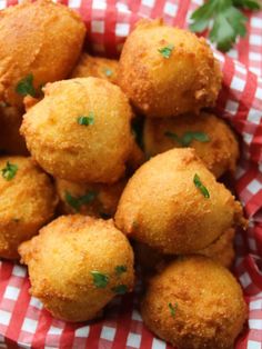 some fried food is sitting on a red and white checkered paper with parsley