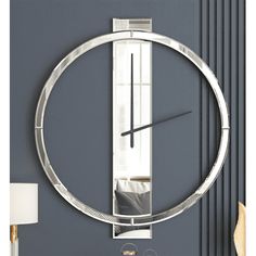 a clock that is on the side of a wall next to a table with a lamp