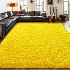 a living room with a large yellow rug on the floor