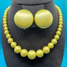 Vintage 1950's, Mid-Century pearlescent chartreuse (yellow-green) beaded necklace with matching clip-on earrings. Choker necklace is adjustable in length from 14' to 16" Clip-on earrings are 1 1/4" across domes. Set is in good condition with some minor normal wear scratches that are not noticeable unless close to the pieces. 1950s Beaded Jewelry, Vintage Yellow Jewelry With Cabochon, Vintage Yellow Cabochon Jewelry, 1950s Necklace, Luxury Vintage Green Clip-on Earrings, Mid-century Green Collectible Jewelry, Bead Choker Necklace, Green Beaded Necklace, Bead Choker