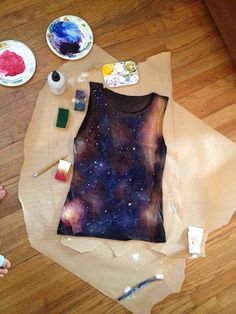 someone is making a t - shirt out of paper with paint and watercolors