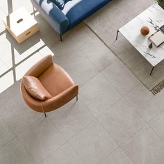 an overhead view of a living room with grey flooring and leather furniture in the middle