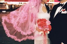 a bride and groom pose for a photo in front of a carnival ride at night