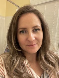 a woman with long hair is taking a selfie in front of the camera and smiling