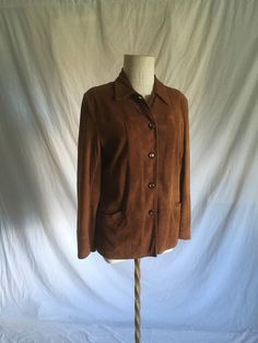 "vintage women's jacket looks to be late 1940s to early 1950s era brown suede, deerskin feel button up collared 2 front pockets lined side waist belt loops inside collar loop for hanging on a hook small soft shoulder pads good vintage condition, authentic age wear-see photos light stains to lining aged patina to leather w/light fray to collar, collar seam repair top button is different label size tag 14(outdated)-fits like a small-see below measures, ,lying flat, shoulder-16\" chest-19\" sleeve-23\" waist/hem-18 1/2\" length from top shoulder next to neck-26\"" Fitted Brown Leather Button-up Jacket, Fitted Brown Leather Jacket With Buttons, Fitted Brown Leather Collared Jacket, Brown Single Breasted Suede Outerwear, Fitted Brown Outerwear With Snap Buttons, Brown Fitted Outerwear With Snap Buttons, Fitted Vintage Brown Outerwear With Pockets, Fitted Suede Outerwear With Button Closure, Vintage Fitted Suede Leather Jacket