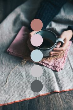 a person holding a cup of coffee on top of a blanket with circles above it