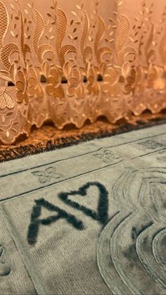 a close up of a rug on the ground near a window with an ornamental design