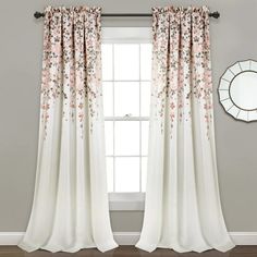 a white curtain with pink flowers on it in front of a gray wall and mirror