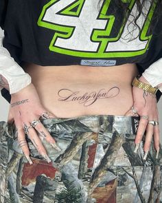 a woman with tattoos on her stomach wearing a skirt