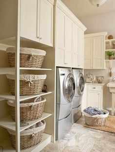 a washer and dryer sitting in a room next to some shelves with baskets on them