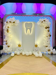 a stage set up with balloons and decorations for a dentist's birthday party or baby shower