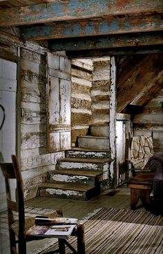 an old log cabin with stairs leading up to the loft