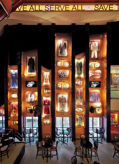 an image of a retail store display with mannequins on the wall and chairs in front