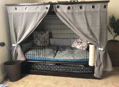 a dog cage with two dogs in it and some pillows on the floor next to them