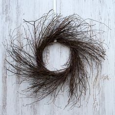 a dried twig wreath on a white wooden background