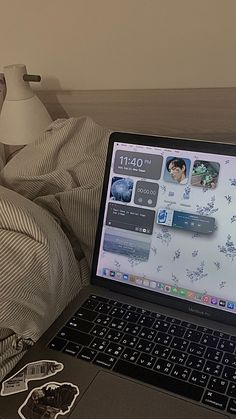 an open laptop computer sitting on top of a bed