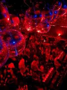 many people are gathered in a room with red and blue lights