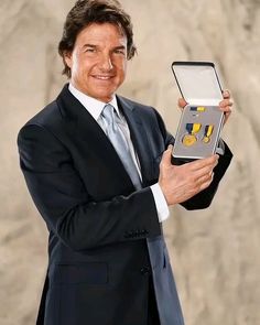 a man in a suit holding up a medal