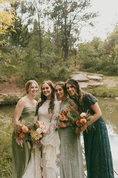 four bridesmaids pose for a photo in front of the water