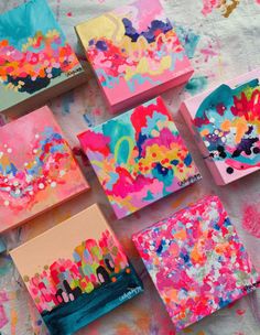 colorful paintings on canvases are arranged in rows