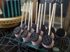 there are many black and white cake pops on the table with some sticks sticking out of them