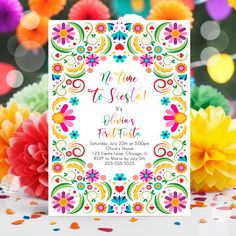 a colorful fiesta themed birthday party with flowers and confetti on the table, including tissue pom poms